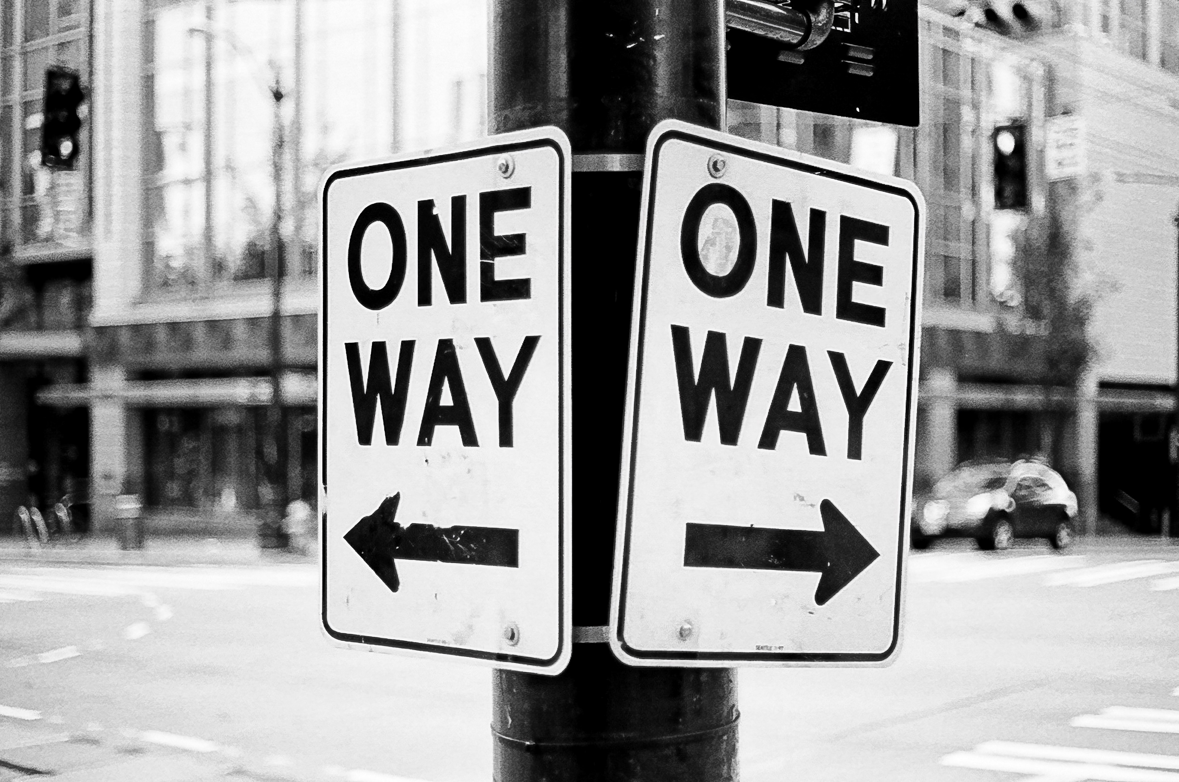 2 one-way signs pointing different directions